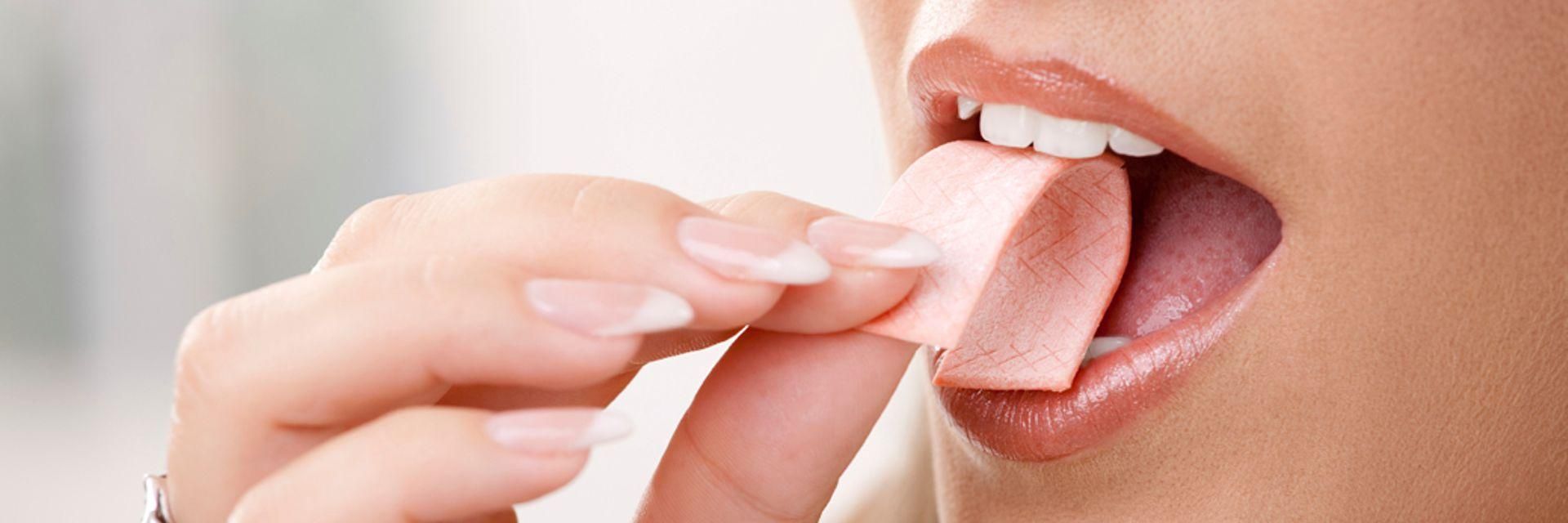 A woman opening her mouth to chew gum