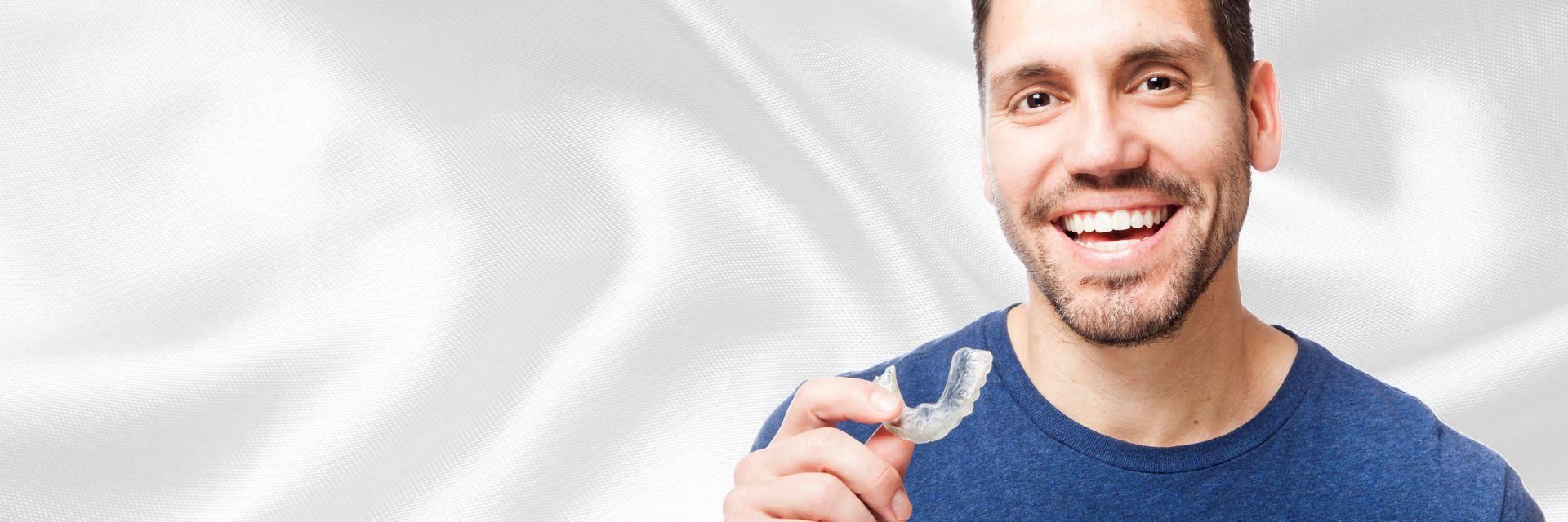 A friendly young man holding a plastic mouth guard