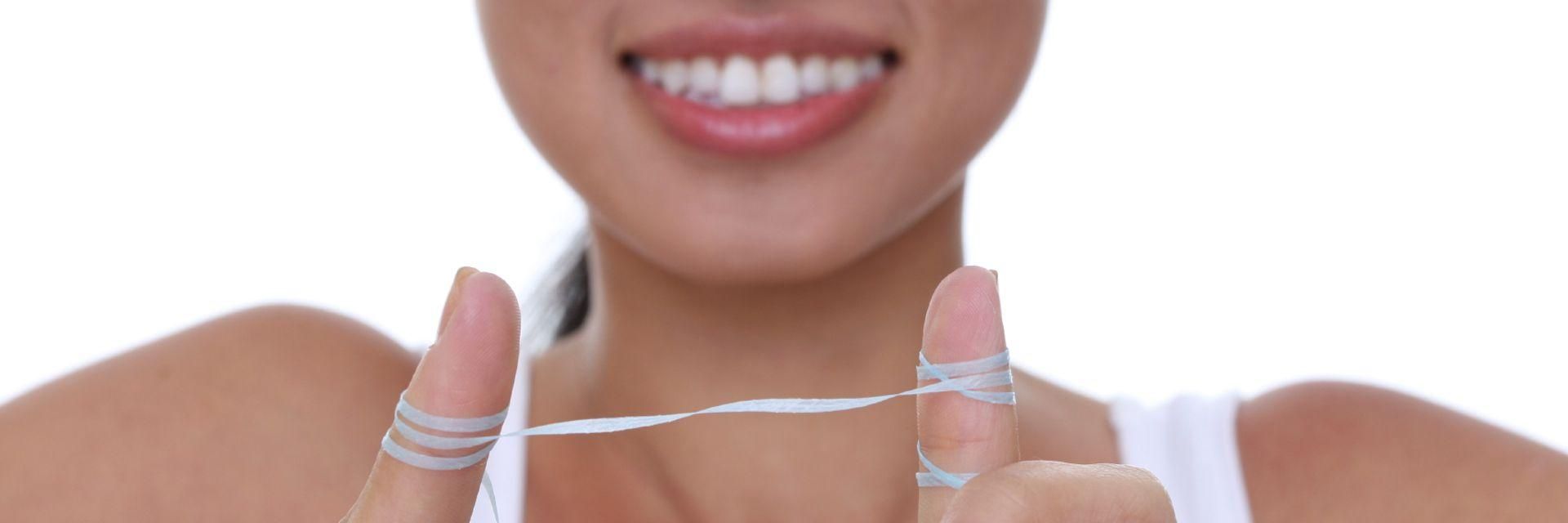 A young woman with dental floss wrapped around her fingers
