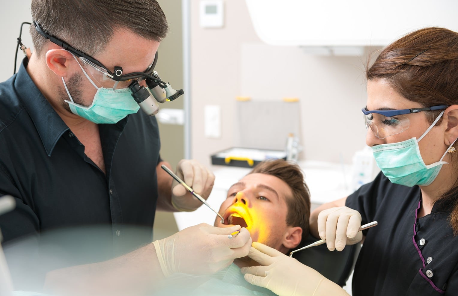 Behandler und Assistenz behandeln gemeinsam einen Patienten bei smileDentity